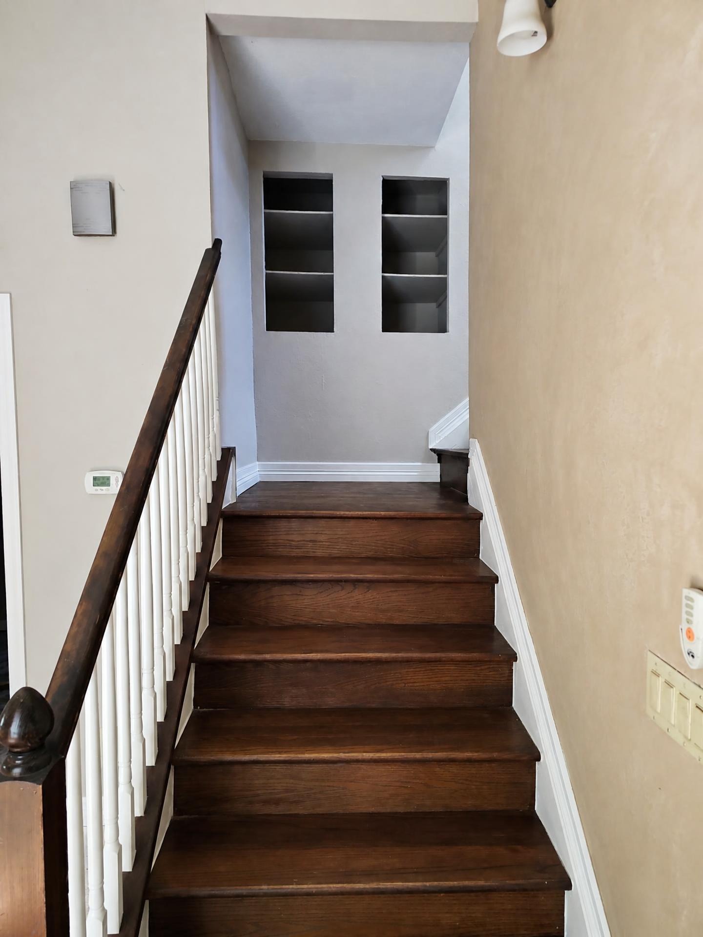 Freshly painted staircase with white risers, dark treads, and clean wall lines
