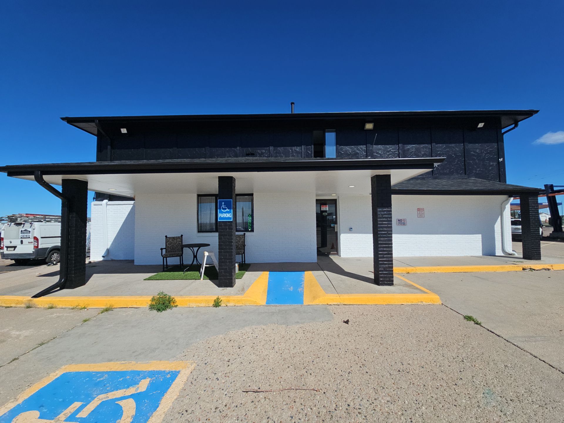 Modern commercial building repainted in white with black upper cladding