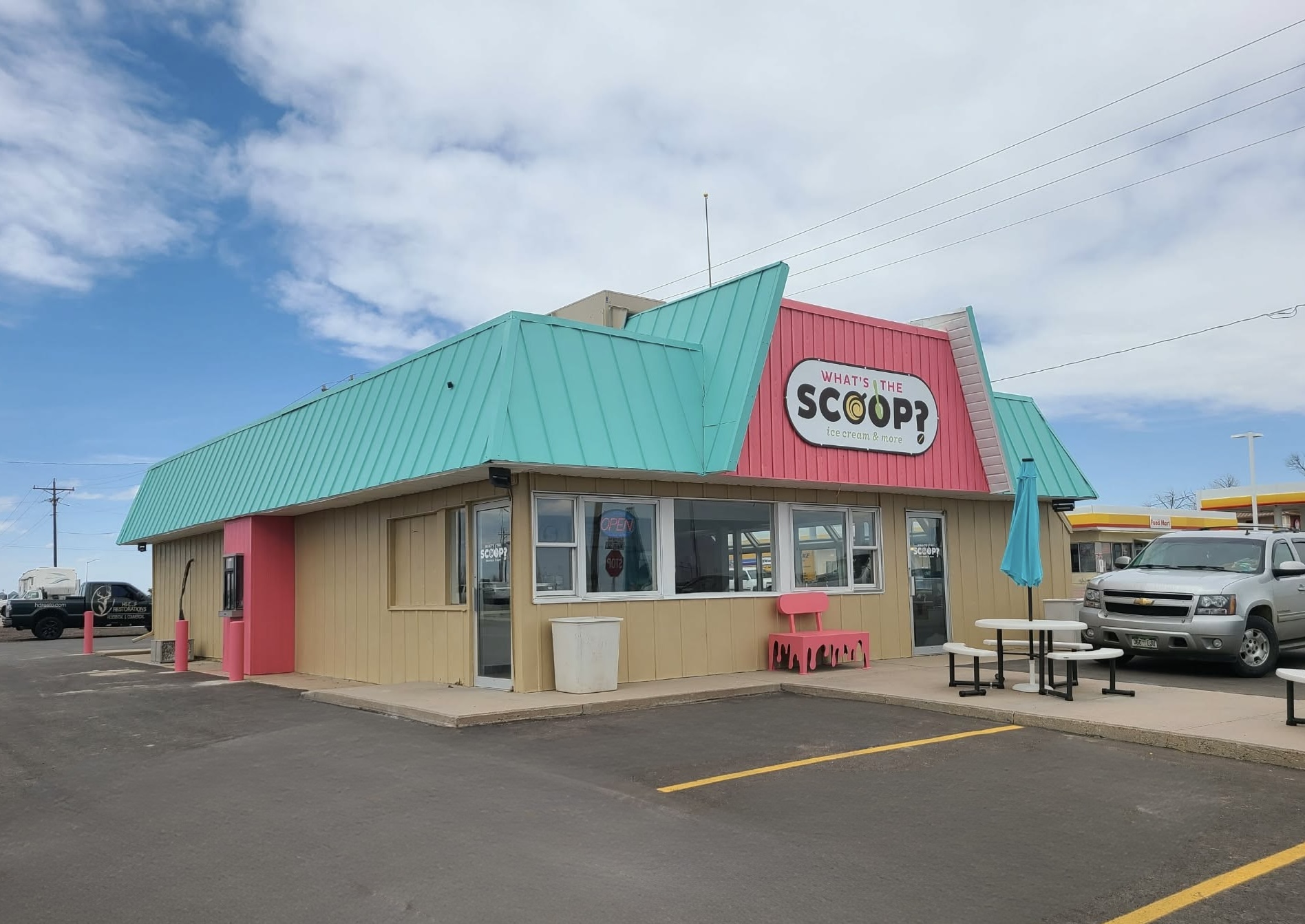 Retail ice cream shop exterior painted cream with teal and pink accents