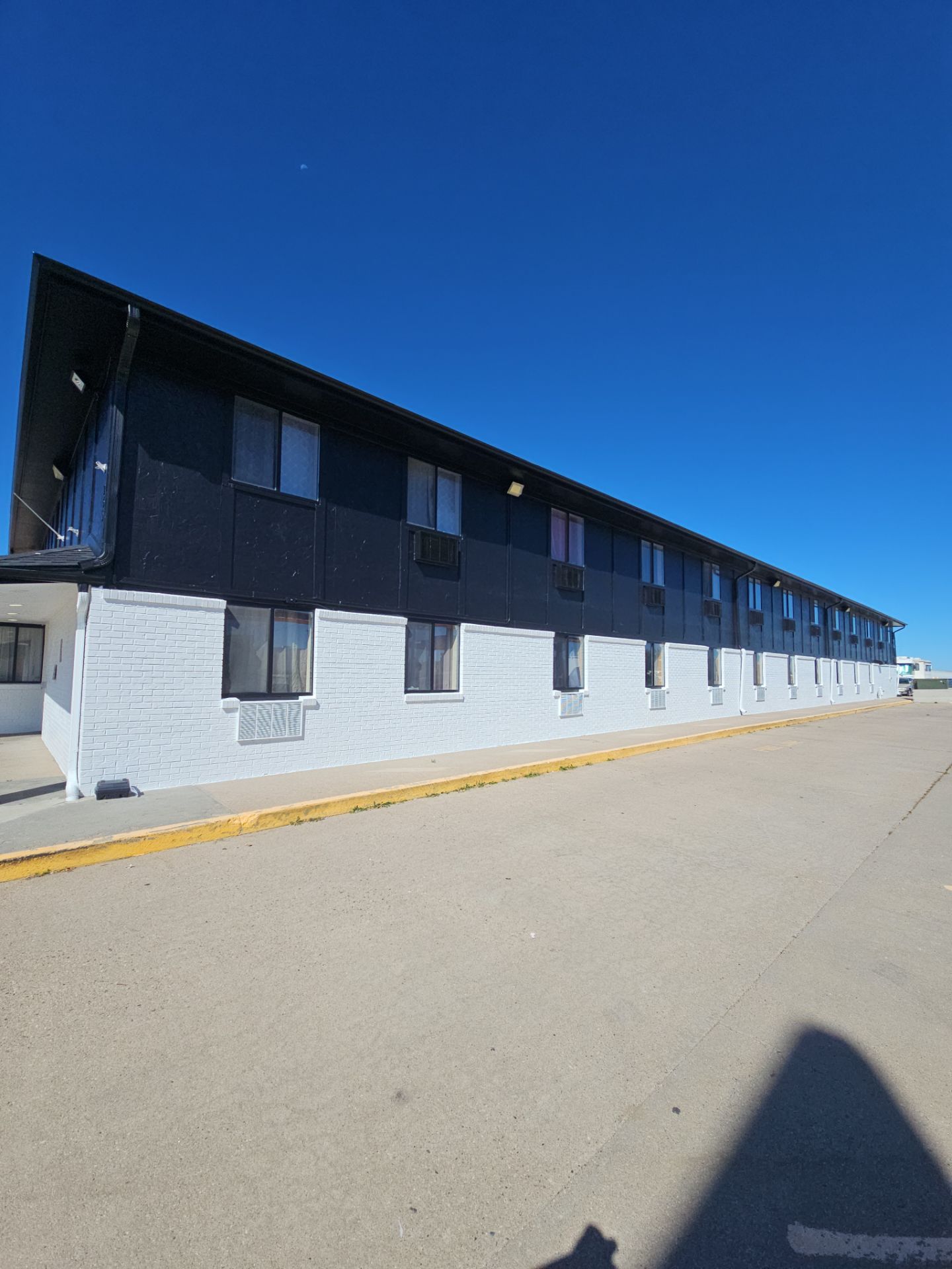 Completed commercial building exterior with white masonry and black siding