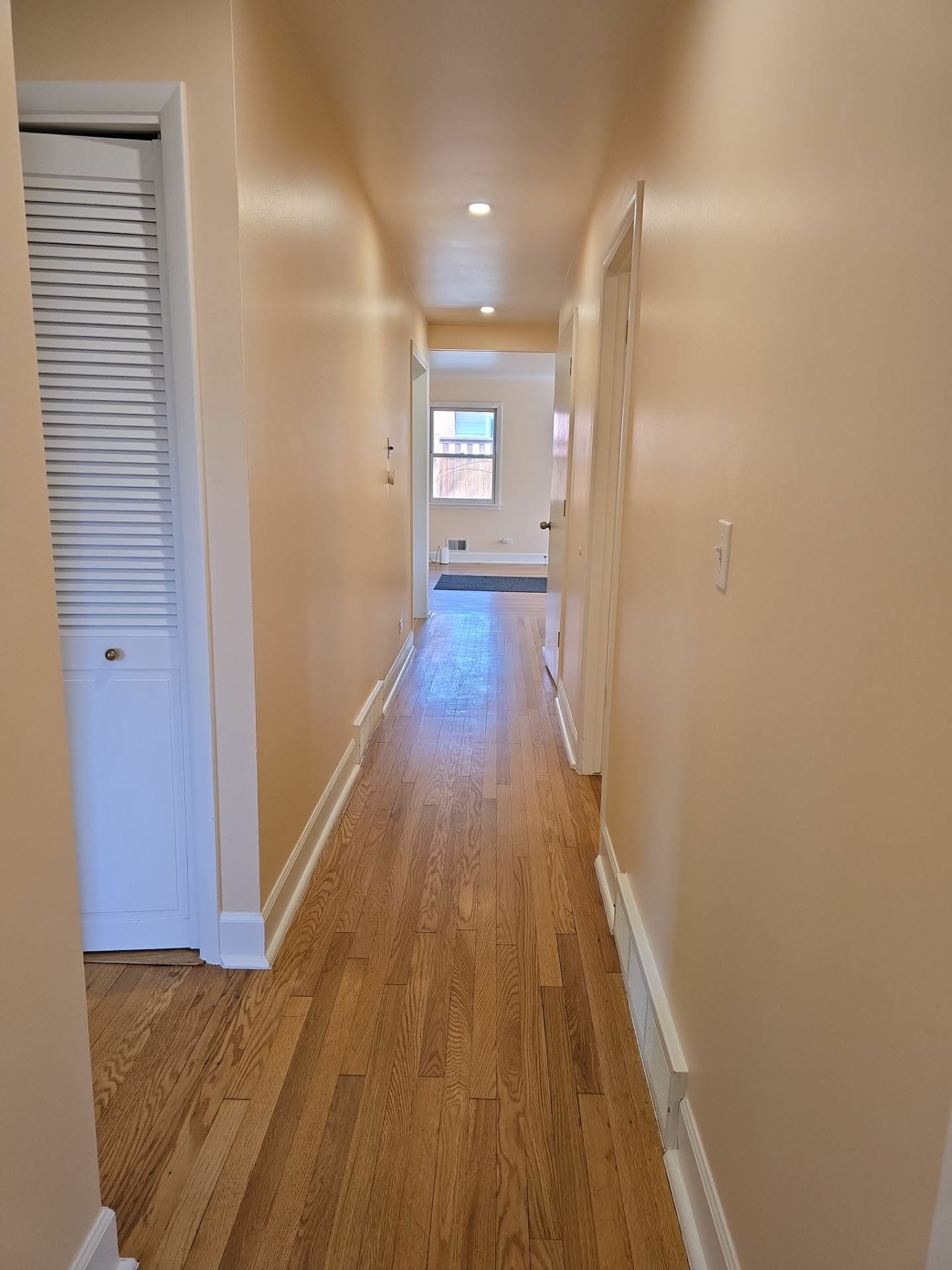 Hallway finished in warm neutral paint with white doors and baseboards